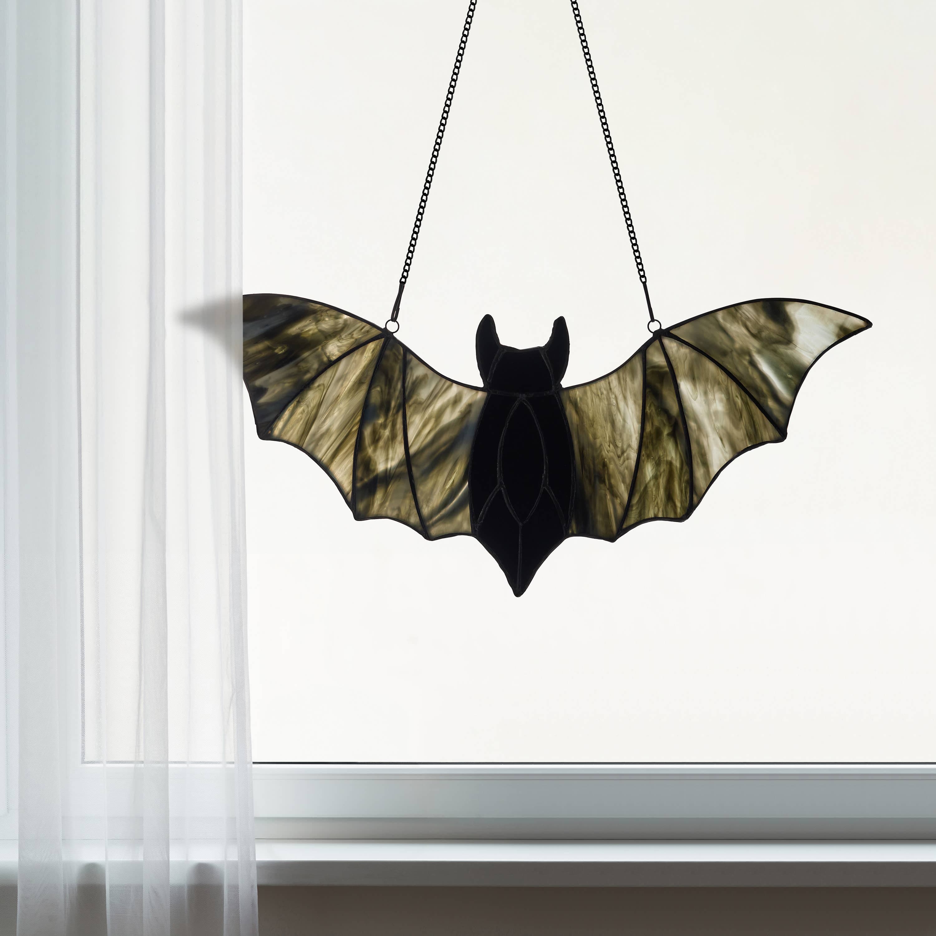 https://cdn.shopify.com/s/files/1/0016/1300/4872/files/river-of-goods-river-of-goods-16-w-halloween-black-bat-stained-glass-window-panel-1192404977.jpg?v=1757625694