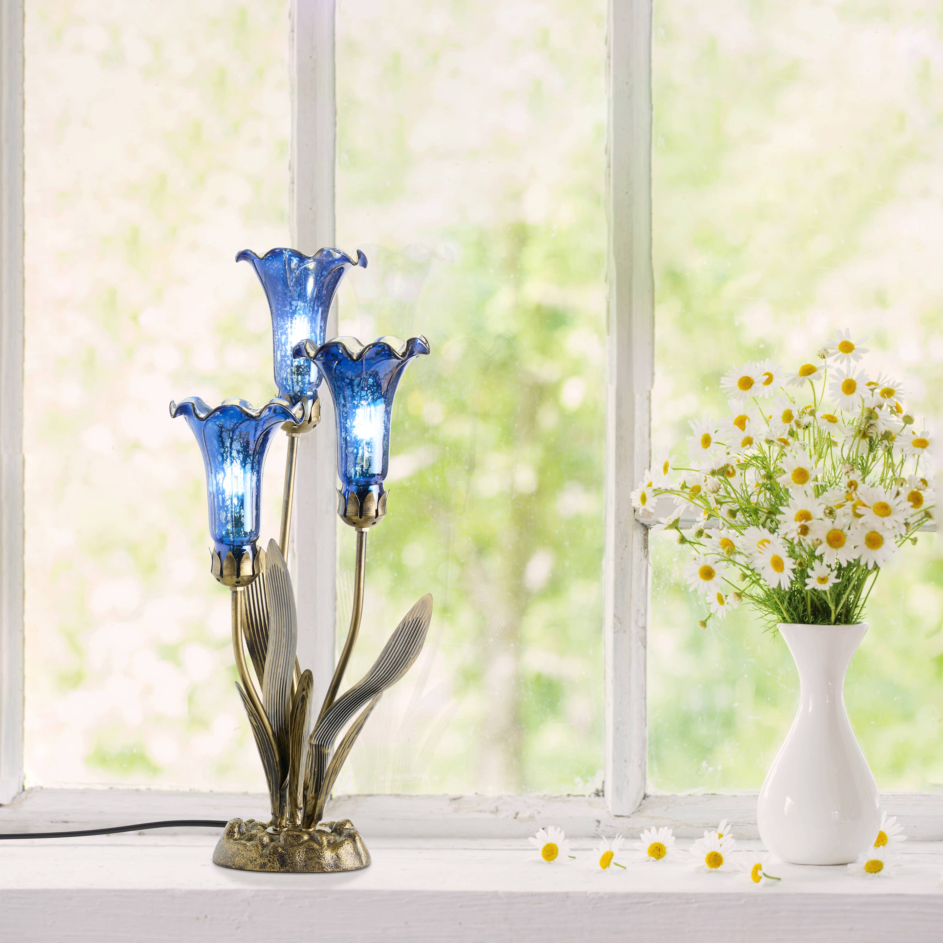 https://cdn.shopify.com/s/files/1/0016/1300/4872/files/river-of-goods-river-of-goods-21-h-blue-mercury-glass-3-lily-uplight-table-lamp-1212805662.jpg?v=1766441129